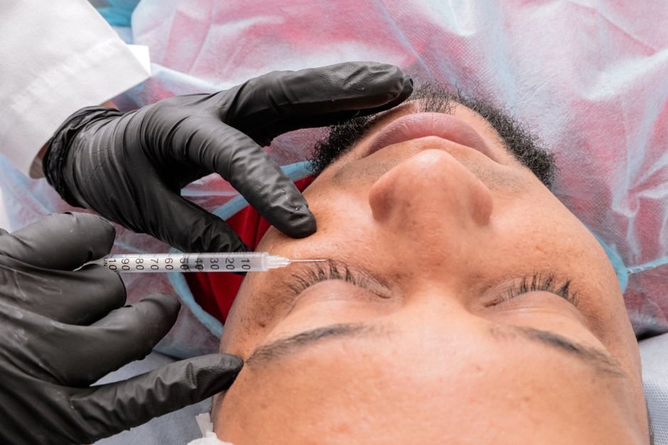 A patient receiving a facial injection in a clinic setting
