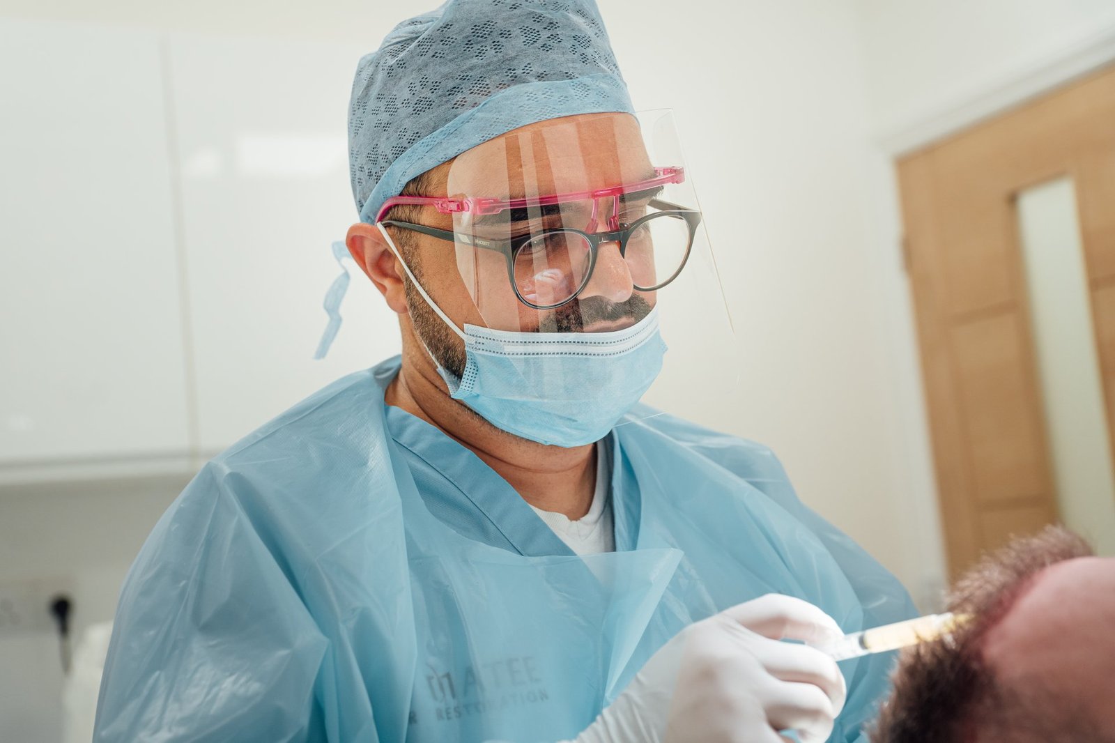 Dr Matee performing an FUE hair transplant in theatre