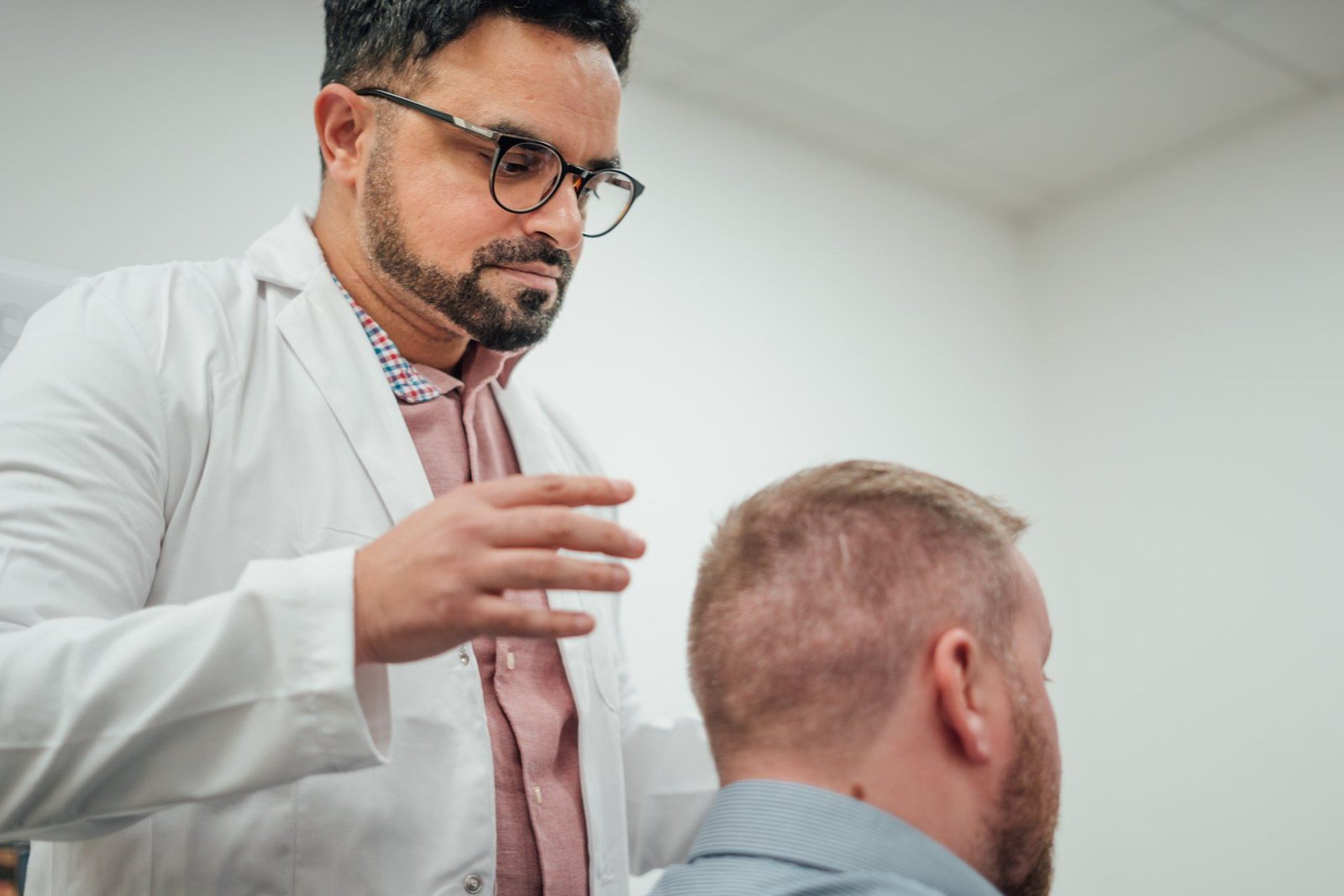 Dr Matee examining a patient's donor area before an FUE hair transplant